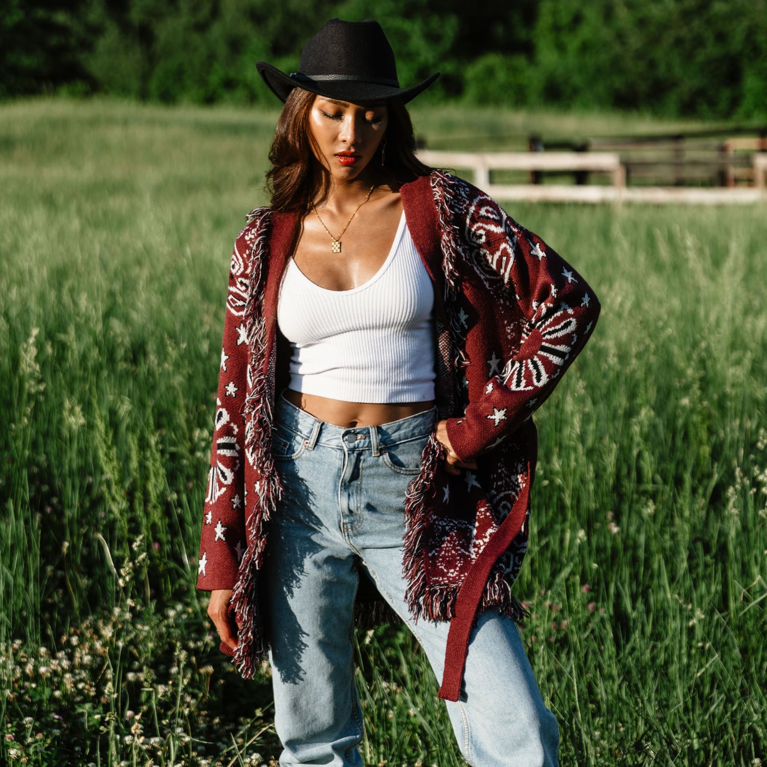 Burgundy bandana fringe cardigan featuring a star and paisley print with fringe details along the edges, designed with a tie belt, open front, and long sleeves.