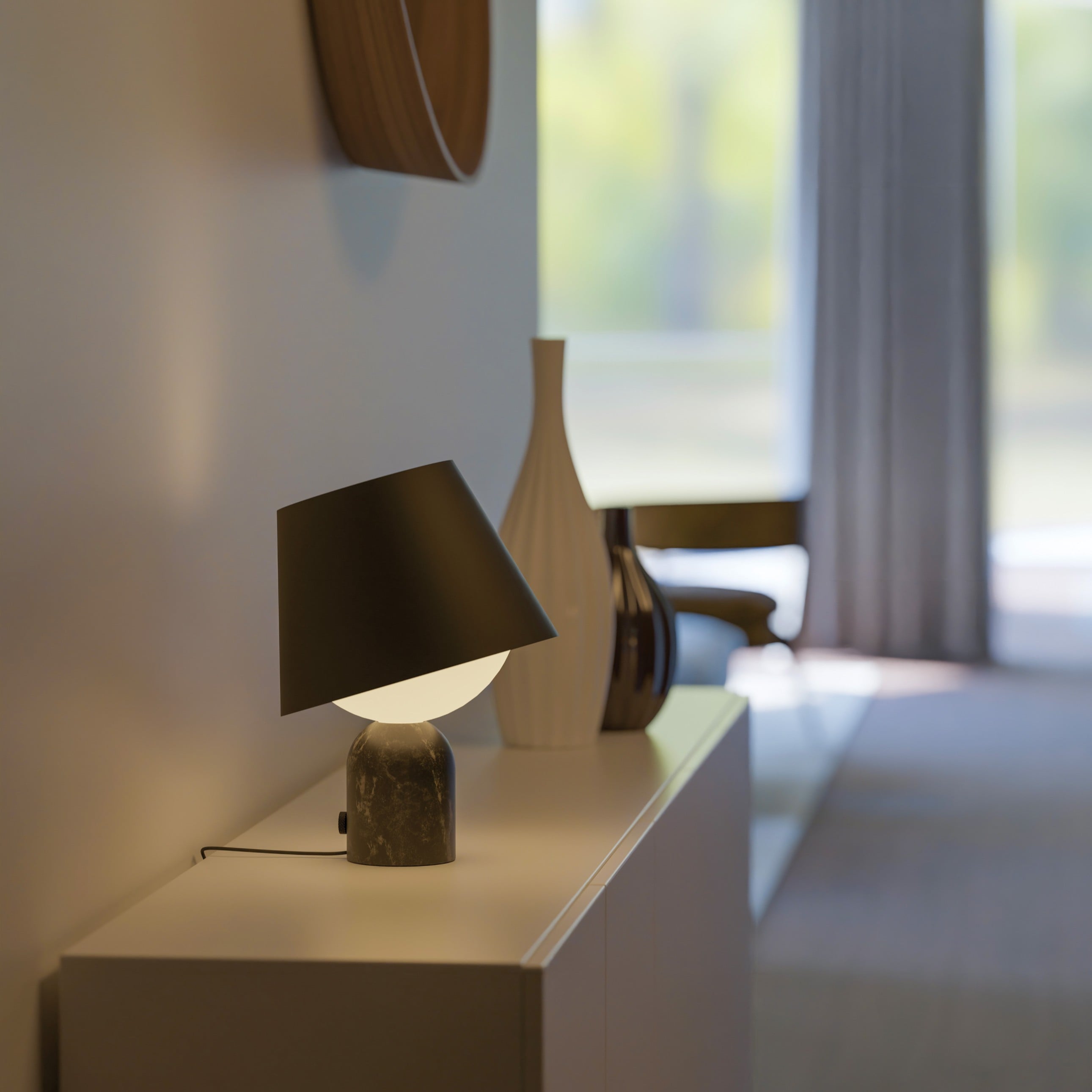 The Dude Table Lamp features a bold silhouette in Carrara white or Marquina black marble, with a tiltable shade, rotary dimmer, and warm 2700K lighting.