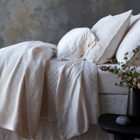 Side view of a monochromatic bed dressed in our new colorways, Natural and Crema.