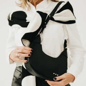 Premium vegan-leather accessory with a sleek crescent silhouette and secure interior pocket that effortlessly transitions from casual days to elevated nights.