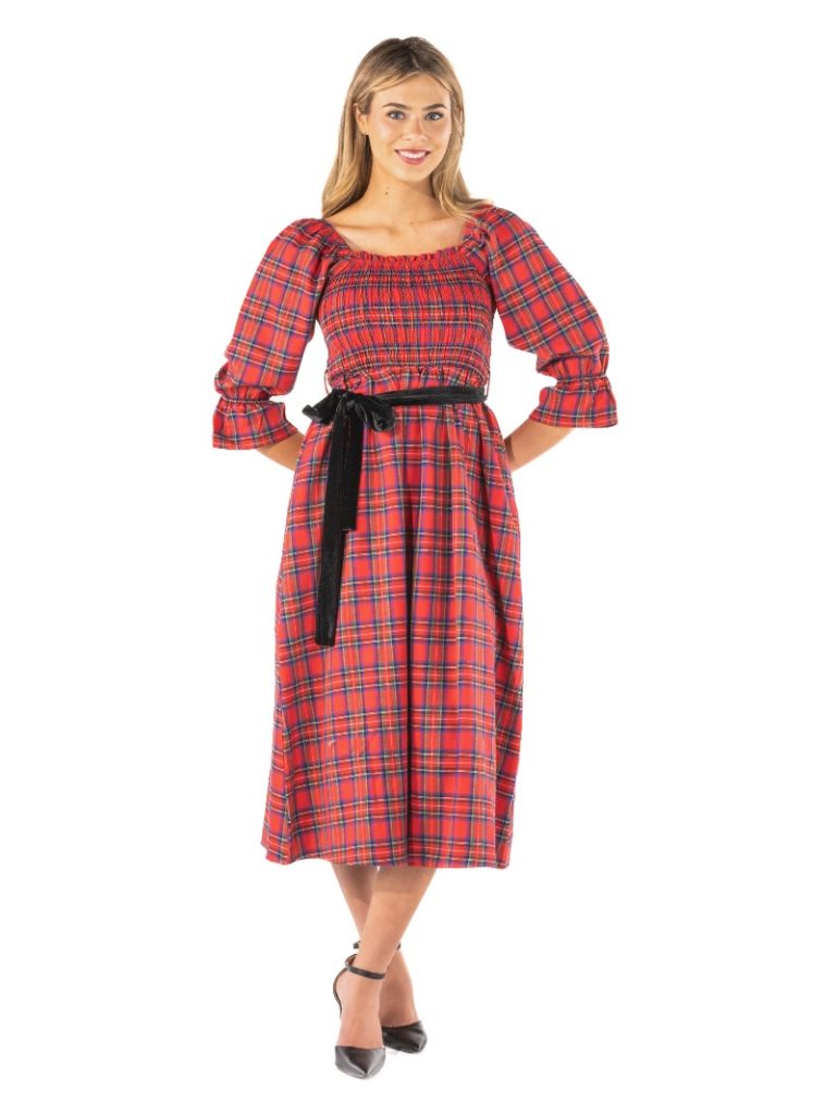 The holiday Smocked dress features a romantic silhouette with rouching, puffed sleeves, and a flared skirt-finished with a black ribbon at the waist. 