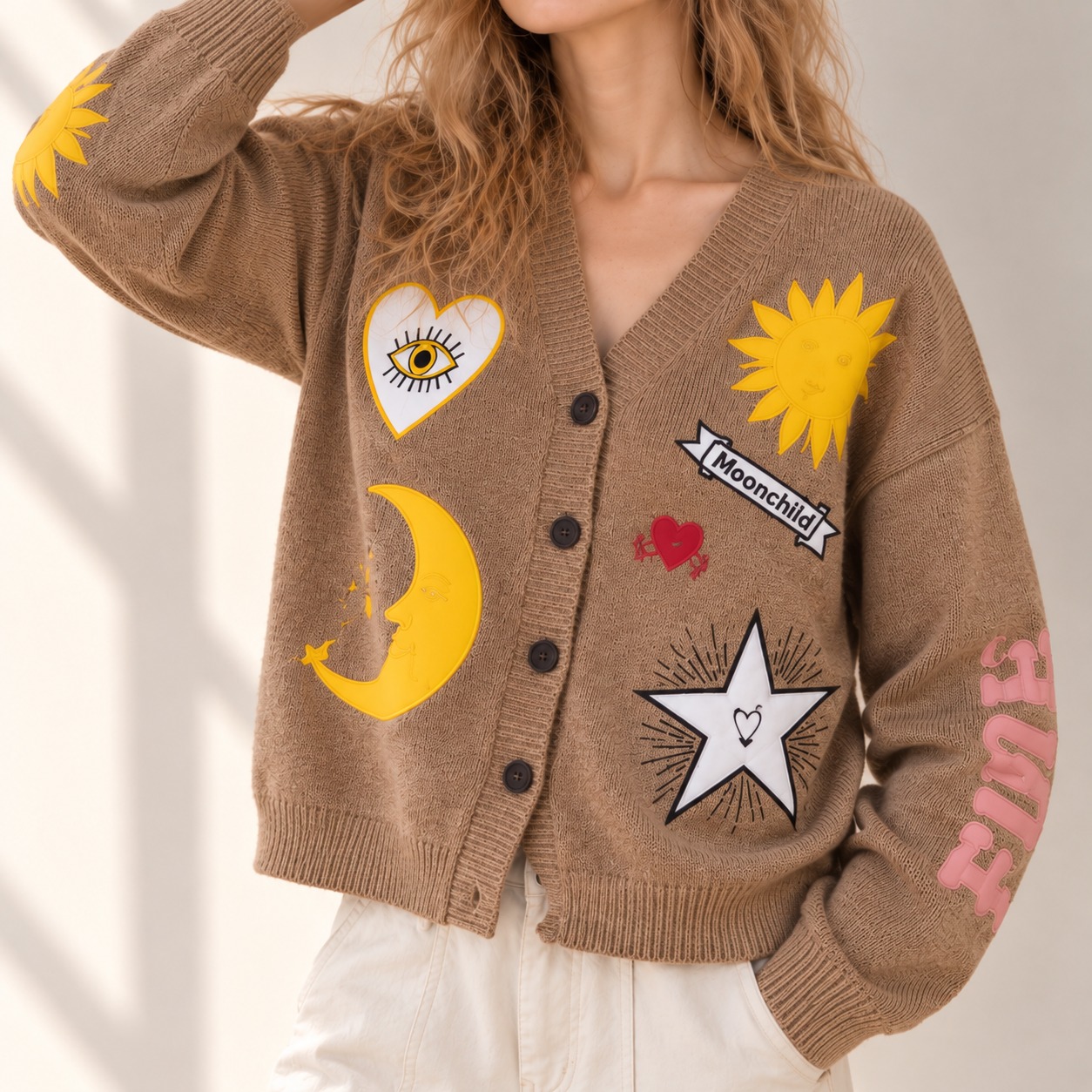 V-neck button-down cardigan with colorful celestial embroidery, featuring sun, moon, star, heart & eye motifs, embroidered sleeve lettering, drop shoulders, long sleeves, and ribbed trims.