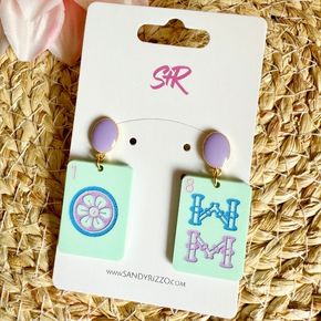 Hand-painted mint acrylic Mahjong tile earrings with blue, purple, and pink accents and a purple oval enamel top! The perfect earring for any Mahjong lover!  *Hypoallergenic and nickel free.