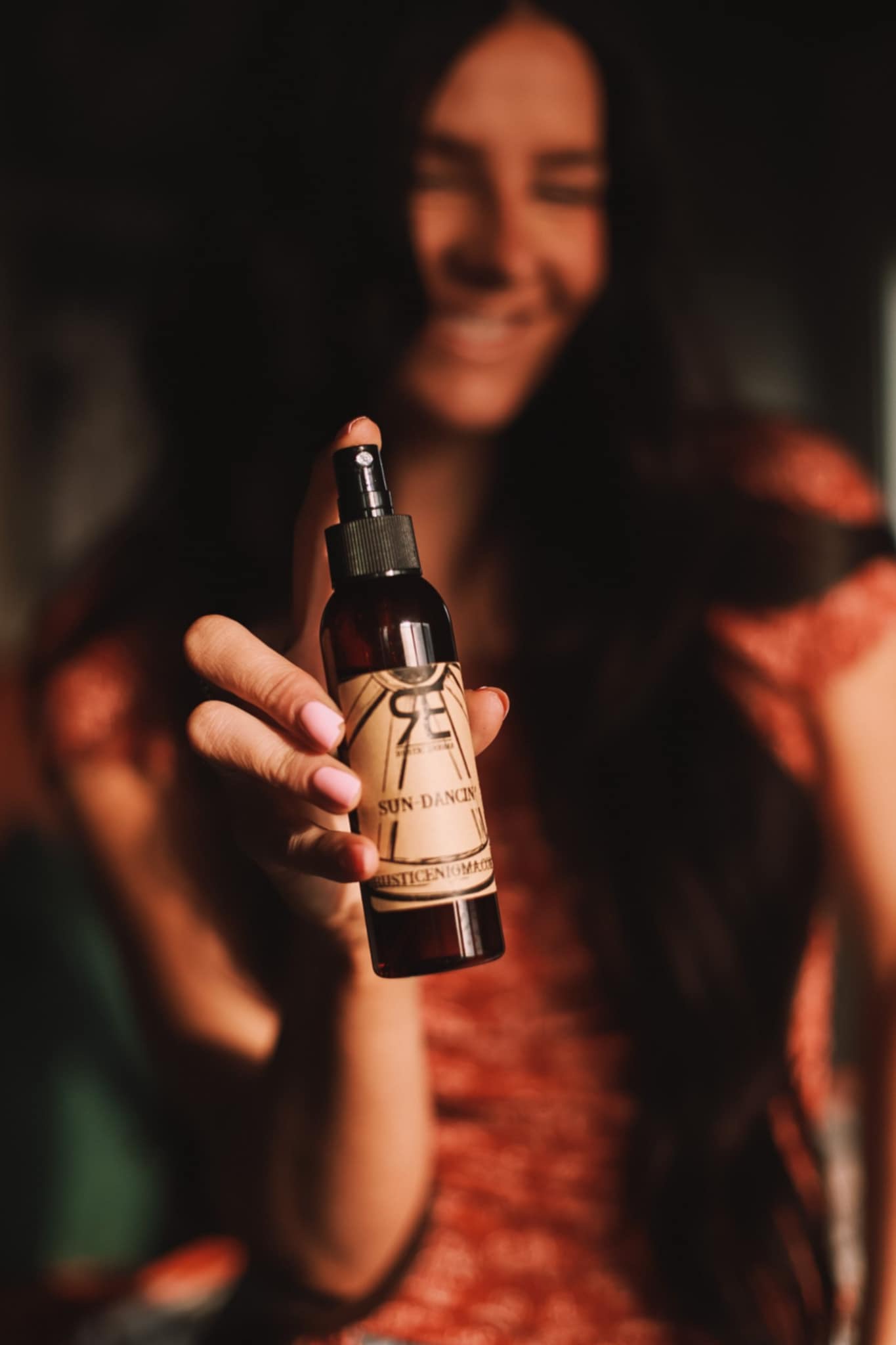 Woman holding a Rustic Enigma room spray