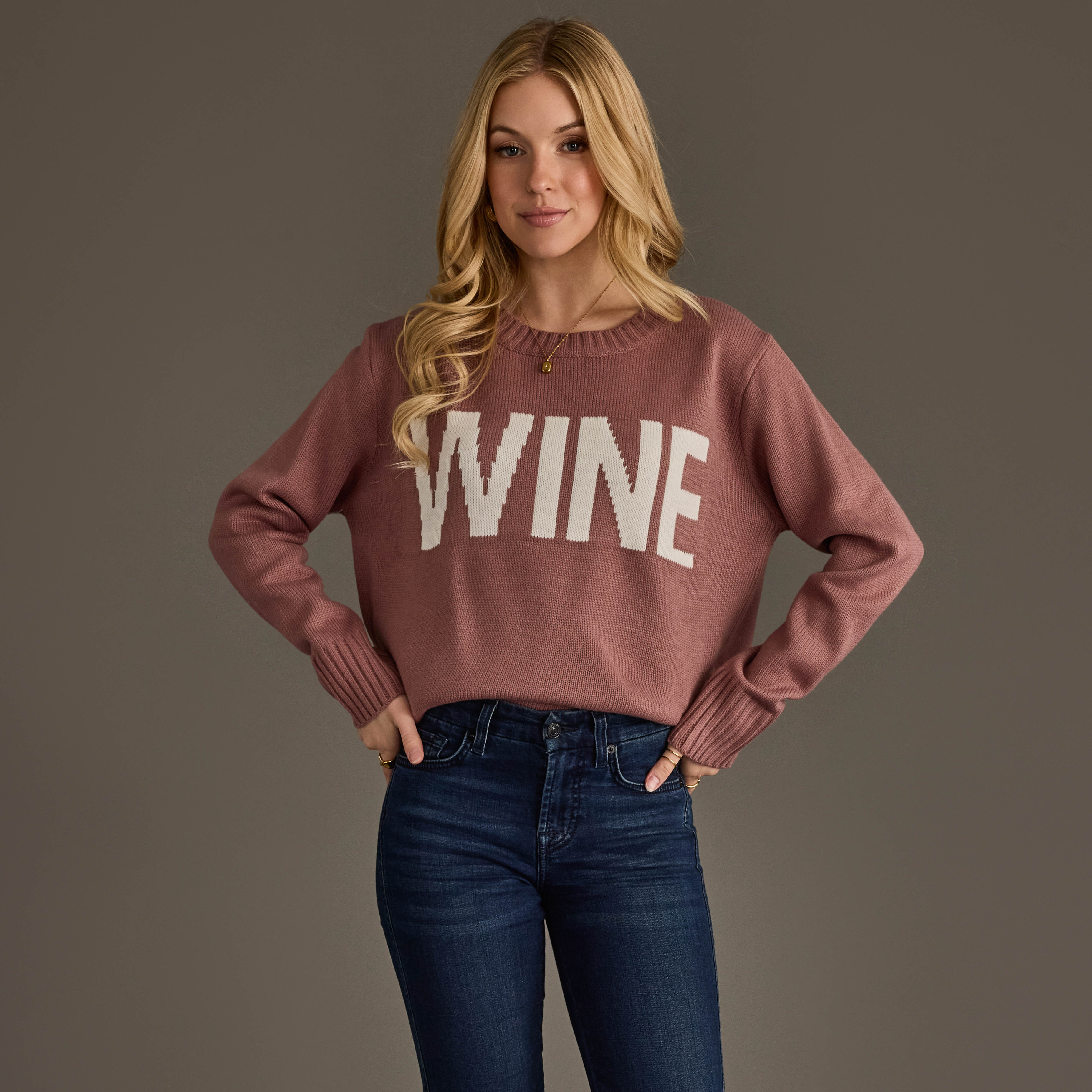 The Mauve and White Wine Sweater features a bold "Wine" knit graphic on the front with white lettering, designed with a classic crew neckline, long sleeves with ribbed cuffs, and a cozy relaxed fit.