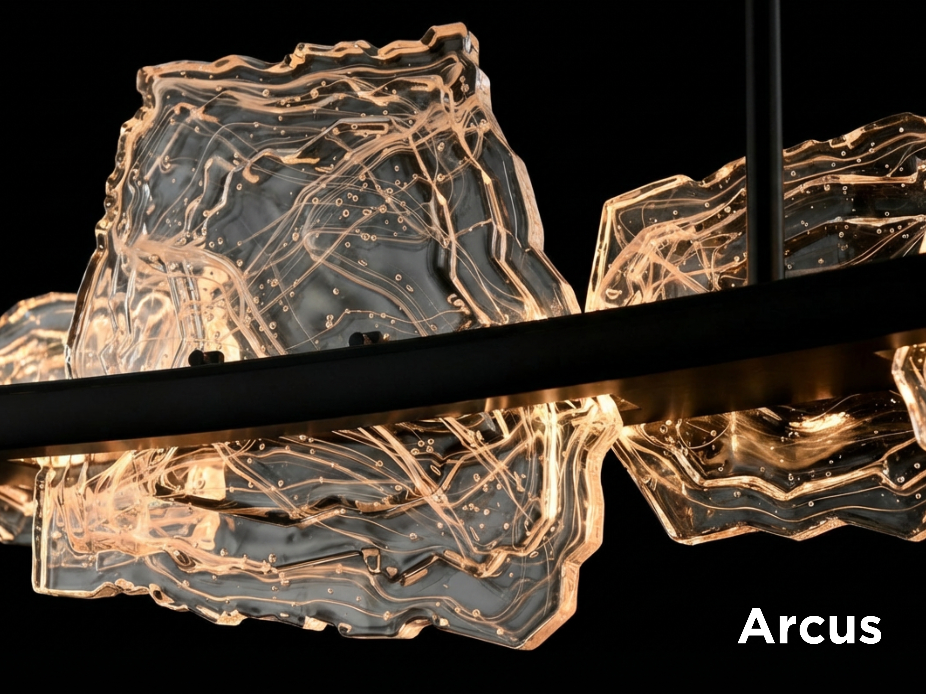 The Arcus Collection features five or seven handcrafted glass panels suspended along sweeping warm brass arcs, available in 50” and 70” designs.