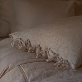 Moody lighting shows the side ties on the new euro and deluxe shams in our embroidered midweight linen collection, Ines.