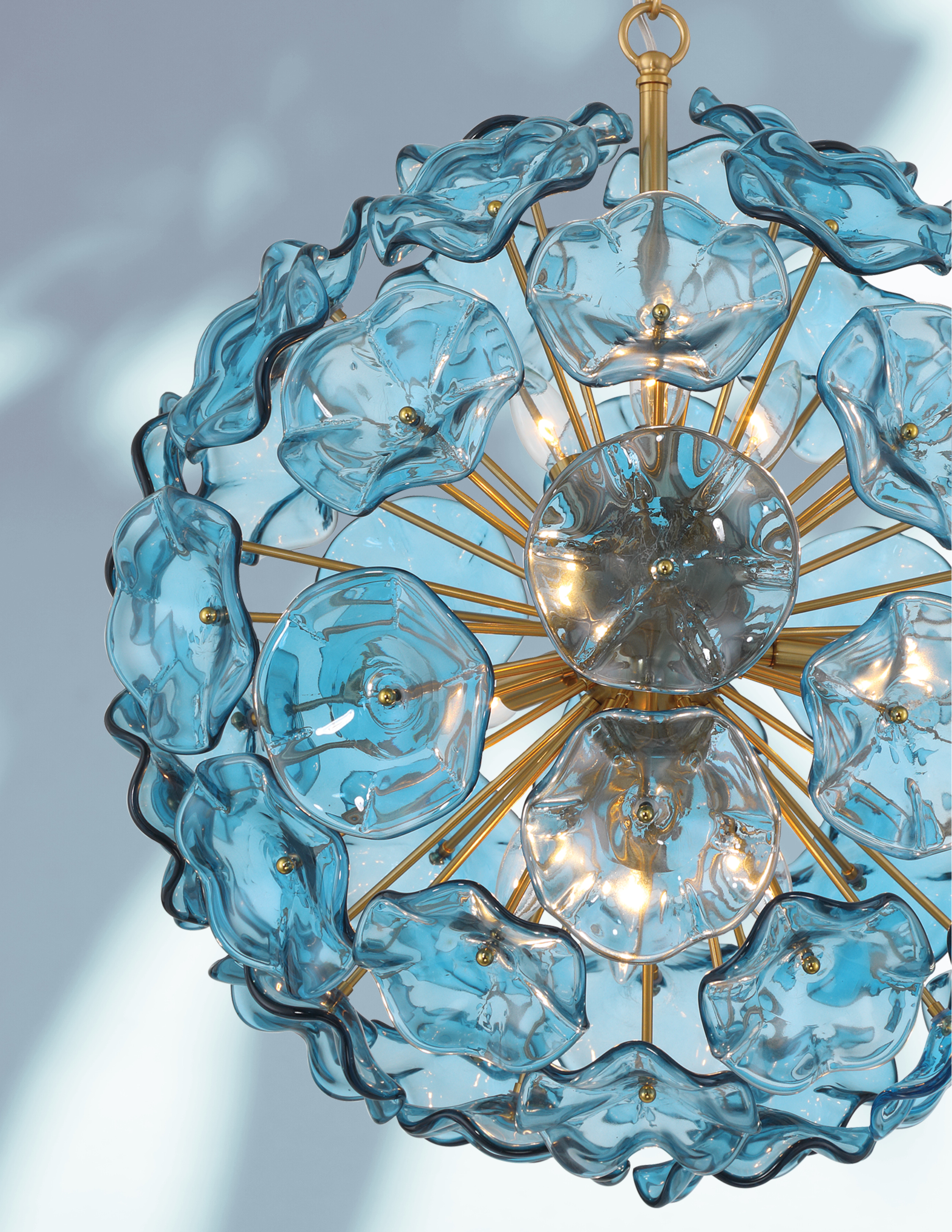 The Esme collection is a modern take on the iconic Sputnik design, blending vintage sophistication with a fresh, dynamic twist including hand-blown art glass shaped like delicate flower petals.