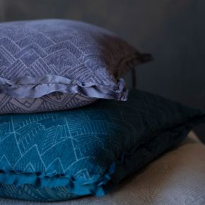 a pair of jewel-toned trettino throw pillows stacked showing the double ruffle trim detail